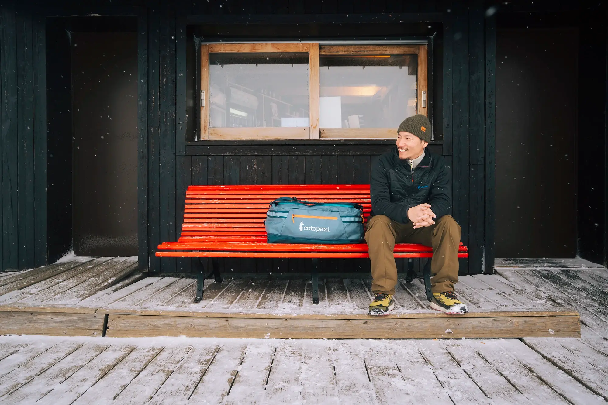 Man sitting in train station, Cotopaxi rucksack, winter photography